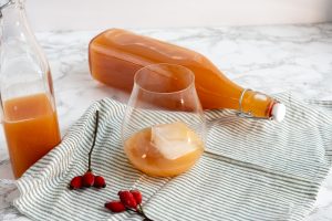 Glass of orange rosehip cordial with ice